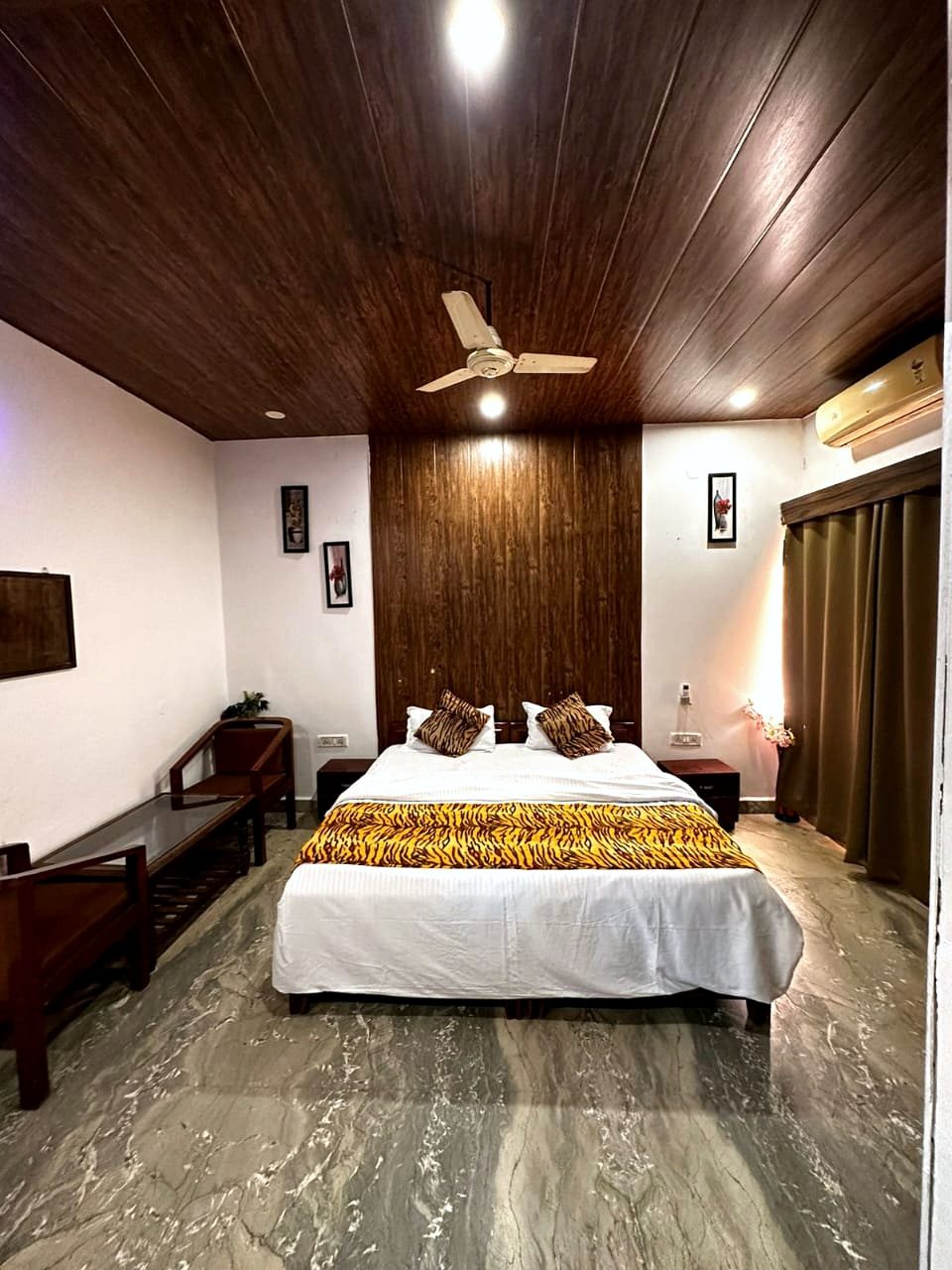 Room with a double bed and tiger-print throw